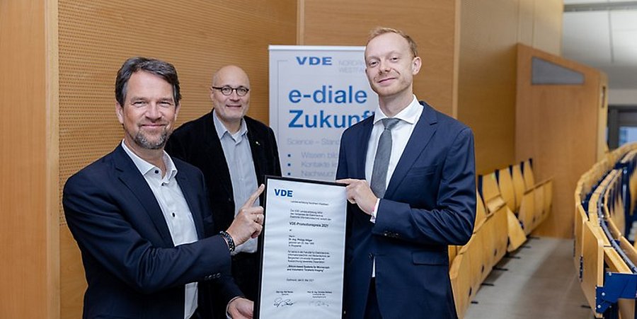 Dr.-Ing. Ralf Berker, Sprecher der VDE Landesvertretung NRW übergibt die Urkunde an Dr.-Ing. Philipp Hillger 